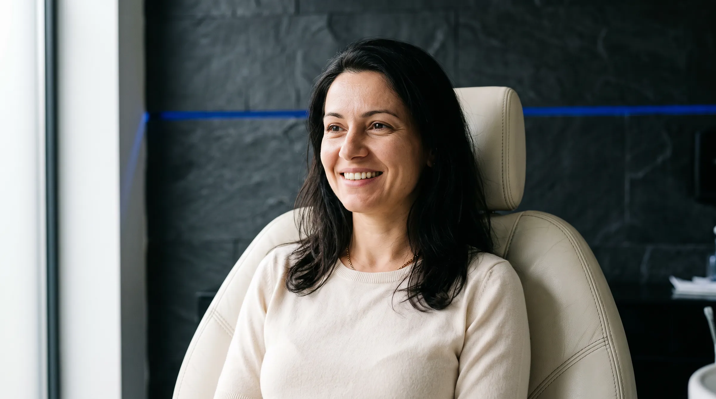 A patient smiling in the dental chair after whitening